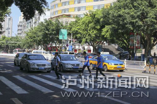 四川警察學(xué)院前的斑馬線沒有紅綠燈，但過(guò)往車輛見到有行人過(guò)斑馬線都會(huì)禮讓行人